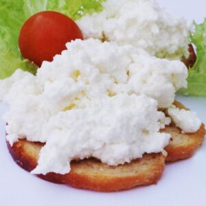 photo of classic cottage cheese on toast with lettuce and a tomato in the background