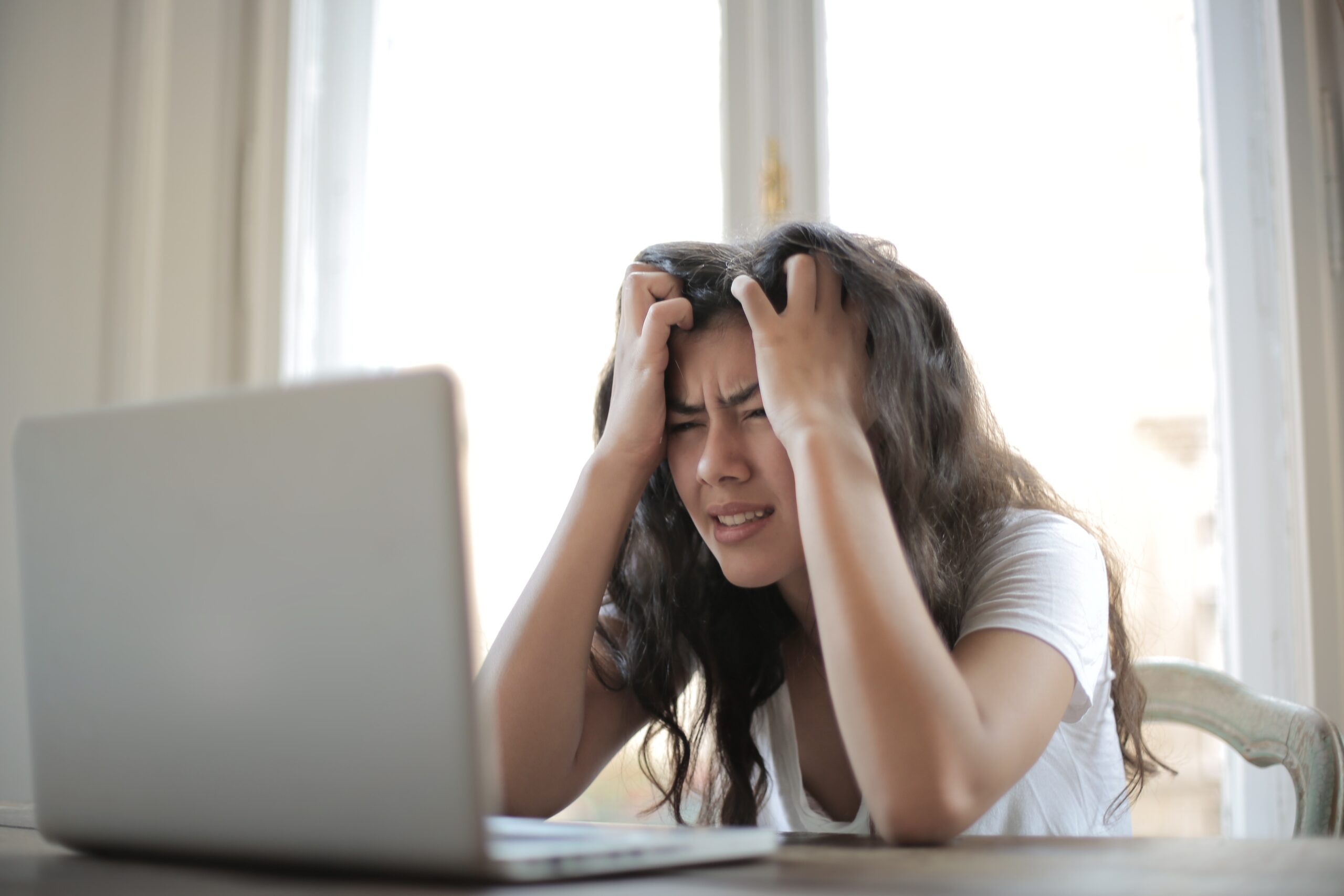 photo of stressed out woman at desk using laptop