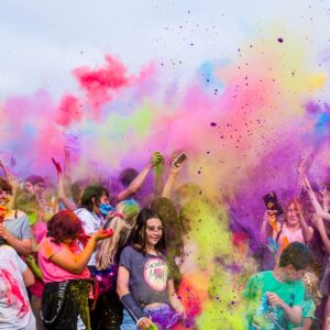 photo of a group of young people celebrating and covering each other in colorful powders