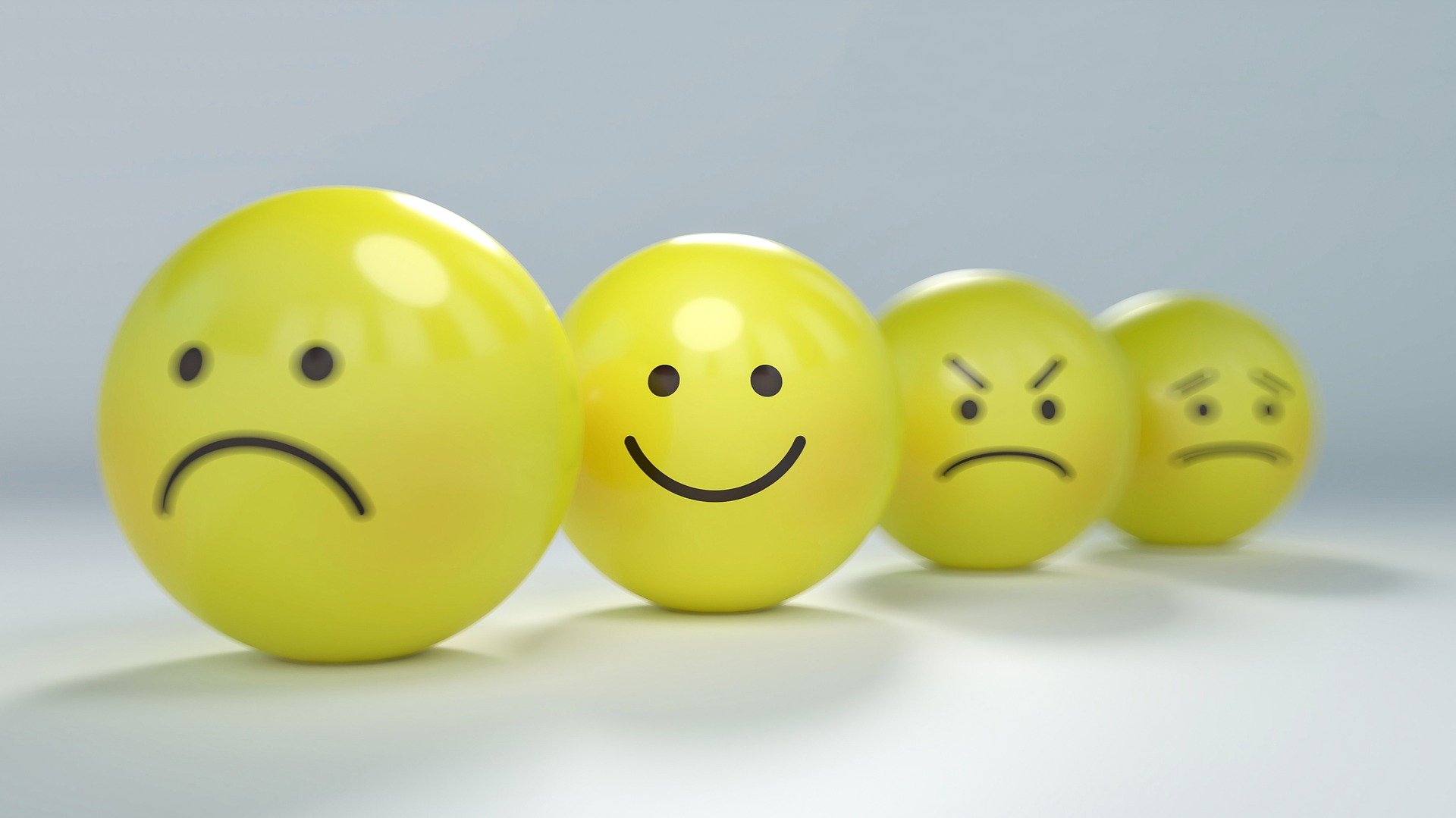 image of a line of yellow balls with emoticon faces of different emotions
